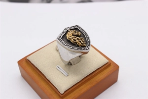 Gros plan de la bague bouclier rétro avec tête de cheval dorée et textures ciselées