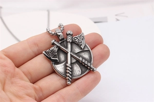 Détail macro de pendentifs haches vikings sur bouclier rond avec chaîne à billes
