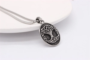 Detailed view of vintage stainless steel Tree of Life pendant with oxidized metal texture