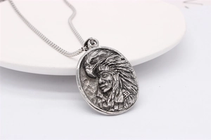 Détail du pendentif relief aigle et chef indien vintage sur une chaîne box