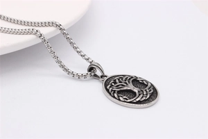 Close-up of vintage silver Tree of Life oval pendant with square box chain detail