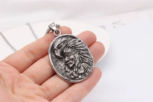 Gros plan du pendentif rétro avec relief d'aigle et de chef en argent vintage