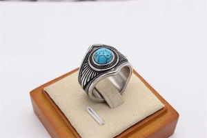 Macro detail of men's vintage titanium steel ring with blue turquoise and feather texture