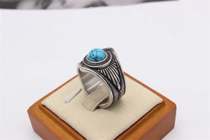 Detailed macro of vintage titanium steel feather ring with turquoise stone inlay