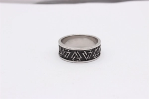 Macro detail of retro steel ring featuring engraved Valknut triangle symbols and matte finish