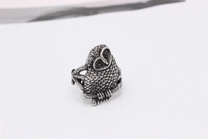 Macro detail of retro owl ring showing intricate feather textures and oxidized steel finish