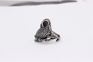 Detailed macro view of vintage owl ring with owl perched on a branch-shaped band