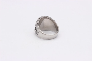 Detail view of the intricate hollow patterns and embossed design on a wide steel skull ring