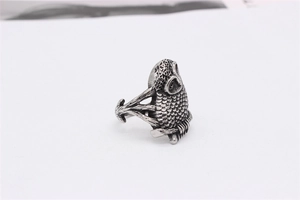 Detailed macro shot of vintage owl ring with oxidized feathers and gothic steel texture
