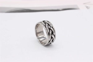 Detailed view of vintage Viking braided knot patterns on a silver steel ring band