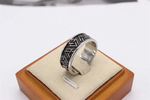 Macro detail of vintage Valknut embossed triangles on stainless steel viking ring band