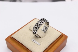 Detailed close-up of retro hollow Celtic knot patterns on a silver stainless steel ring