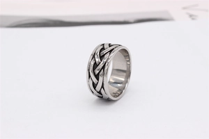 Close-up of vintage Celtic knot woven texture on men's stainless steel wide band ring