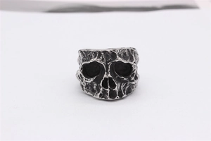 Detail of retro gothic skull ring featuring textured lava-like finish and oxidised steel