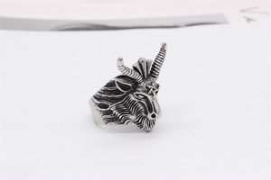 Detail of vintage gothic goat head ring with pentagram and textured horns in steel