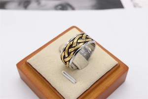 Detail of vintage Viking woven pattern on dual-tone gold and silver steel ring