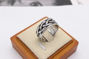 Detailed close-up of retro silver Celtic knot woven texture on vintage men's steel ring