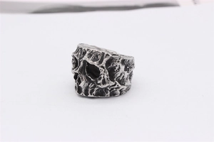Macro shot of retro silver skull ring with industrial rock texture and cracked metal finish