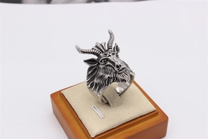 Detailed close-up of a silver gothic ram head ring with spiral horns and pentagram