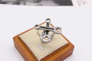 Macro detail of vintage silver wrench ring on a beige velvet jewelry display stand