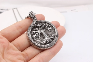 Detailed close-up of retro silver Tree of Life pendant with serpent scale texture