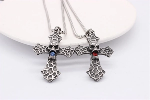 Close-up of gothic skull cross pendants with vintage red and blue gemstones