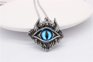 Makroaufnahme des Gothic-Anhängers mit Totenköpfen und blauem Auge aus Edelstahl