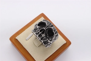 Macro shot of vintage skull ring with oxidized finish and rocky texture details