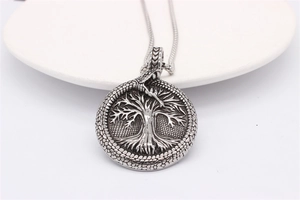 Macro view of vintage silver Tree of Life pendant with Ouroboros on wheat chain