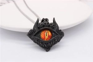 Nahaufnahme des gotischen Totenkopf-Anhänger mit roter Pupille und Vintage-Metalltextur