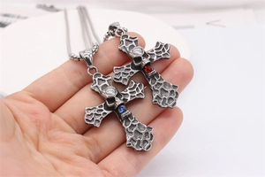 Close-up of vintage skull cross pendants with red and blue gems in stainless steel