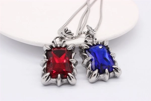 Gros plan des pendentifs gothiques rétro avec pierres précieuses rouges et bleues et griffes