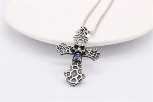 Macro detail of gothic skull cross pendant with blue rhinestone on a silver snake chain