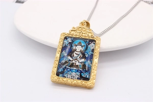 Detail of vintage gold zodiac pendant with colorful Buddhist Thangka art and steel chain