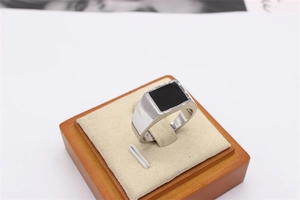 Macro shot of silver titanium steel signet ring with rectangular black enamel inlay