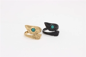 Detail of vintage steel feather rings in gold and black with turquoise center stone