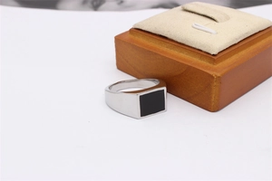 Macro view of men's square stainless steel signet ring with black enamel inlay detail