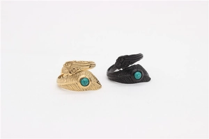 Macro detail of feather textured rings with turquoise beads in gold and black finishes