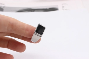 Close-up of a silver titanium steel ring for men with a black enamel rectangular inlay