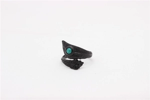 Macro shot of retro feather stainless steel ring with turquoise stone inlay and cloud patterns