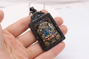 Close-up of Mahakala Thangka pendant with retro scrolls and stainless steel bead chain