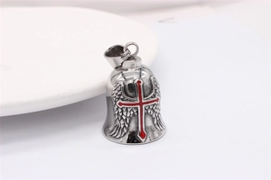 Detail of vintage steel bell pendant with red cross and wings on white plate