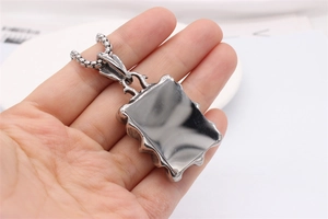 Détail du pendentif rectangulaire aux bords ondulés rétro sur une chaîne en acier robuste