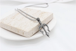 Macro detail of retro trident pendant with intricate vintage engravings on textured stone