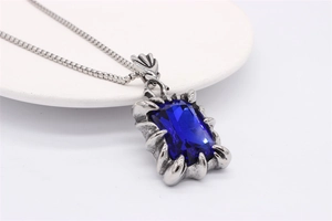 Détail du pendentif avec gemme bleue rectangulaire et griffes de dragon argent antique