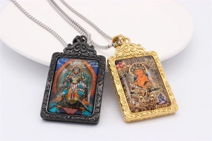 Detailed view of Thangka style rectangular pendants with relief scrollwork and bead chain