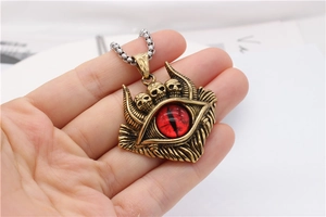 Nahaufnahme von Gothic-Anhänger mit Totenköpfen und rotem Teufelsauge an Metallkette