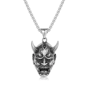 Close-up of vintage Hannya mask pendant with distressed silver finish on chain