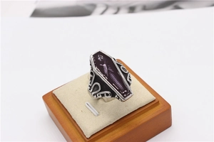 Detail view of gothic coffin ring with purple enamel and vintage scrollwork patterns