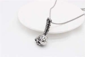 Macro view of gothic skull and spine pendant on a stainless steel box chain necklace